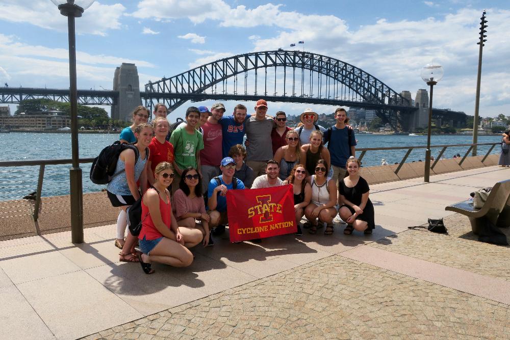 Group poses in front of Sydney's Bay Bridge